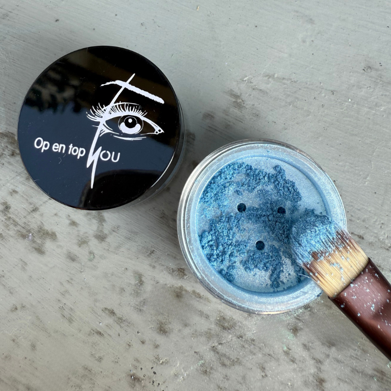 Een potje minerale make-up oogschaduw in de kleur 'Blauw Bologna' met een glans. De oogschaduw heeft een intense blauwe kleur met een glitter