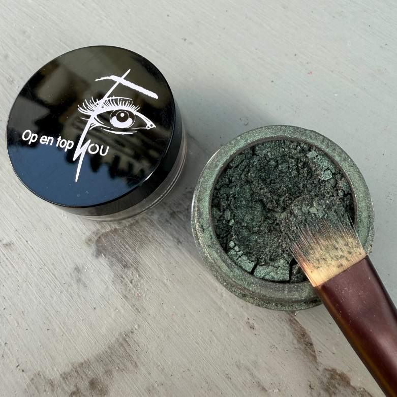 Minerale oogschaduw in de kleur Jade Jean, een diep groene, mysterieuze tint met een subtiele glans en een losse, poederige textuur.