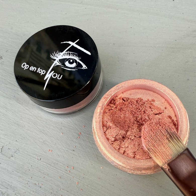 Een potje minerale oogschaduw Koraal Kreta met een glanzende rood-oranje tint en een subtiele gouden gloed, in losse poedervorm, gemaakt van natuurlijke en microplasticvrije ingrediënten.