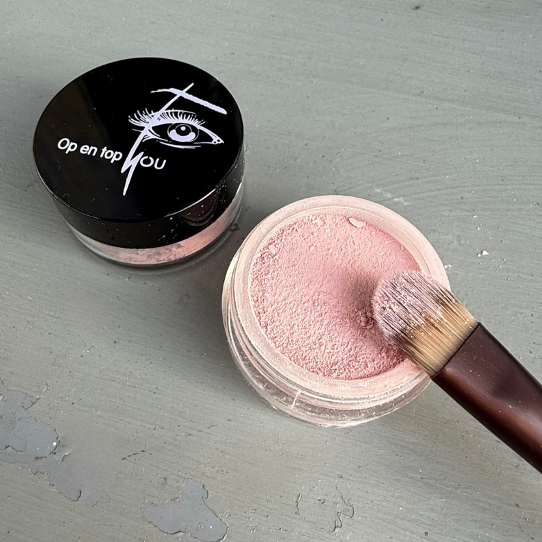 Een klein rond potje minerale oogschaduw in de kleur Roze Rhodos, een matte pasteltint in een losse, poederige textuur.