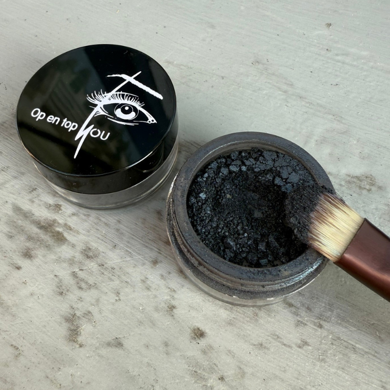 Een potje minerale make-up oogschaduw in de kleur 'Graniet Granada' met een satijnglans. De oogschaduw heeft een intense zwarte kleur met een subtiele glinstering.