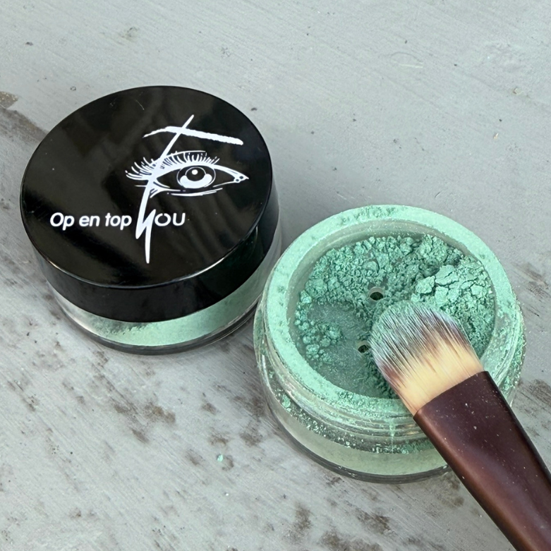 Een potje minerale make-up oogschaduw in de kleur 'Turquoise Toulouse' met een zijdeglans. De oogschaduw heeft een intense groene tint.